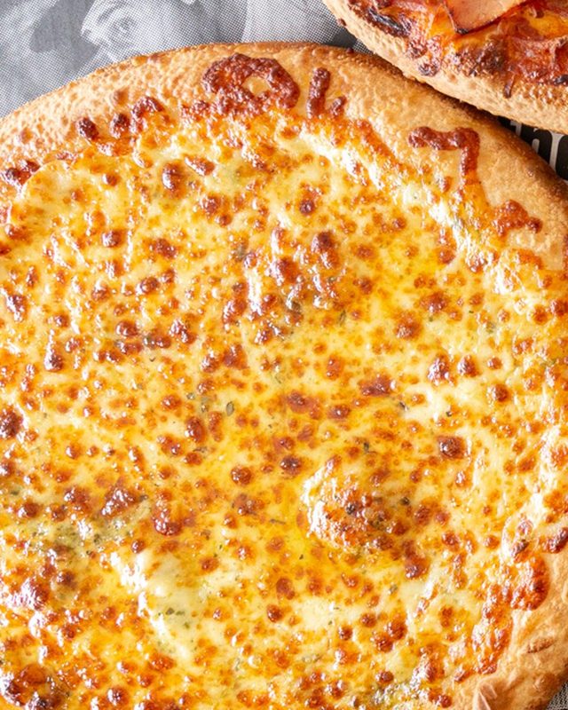 Close-up of a golden, bubbling cheese pizza fresh from the oven